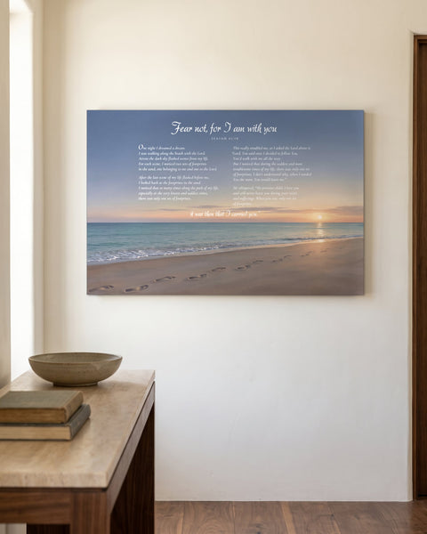 Footprints in the Sand painting-style canvas with a beach sunrise and the full poem, hanging on an ivory plaster wall above a walnut console