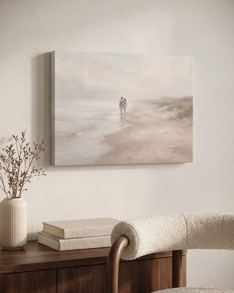 Muted coastal canvas of two figures walking a misty shore, hung above a walnut console