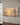 Panoramic canvas of Jesus walking on the Sea of Galilee at sunset, hanging on a warm plaster wall above a walnut console