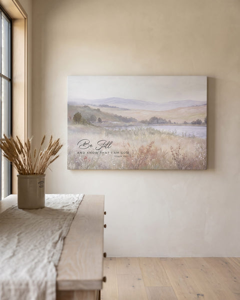 Misty meadow and lake landscape canvas with Be Still and Know Psalm 46:10 hanging on an oat limewashed plaster wall