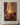 Canvas of a woman's hand touching the glowing hem of Jesus' robe, hung on a warm plaster wall above a walnut console