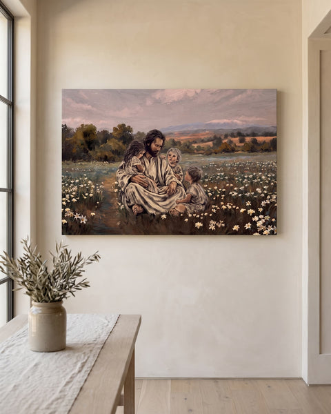 Landscape canvas of Jesus seated among white lilies with three children, centered on a limewashed plaster wall above an oak console