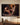 Dark oil painting canvas of Christ kneeling to offer a broken man the missing puzzle piece, hung above a walnut console