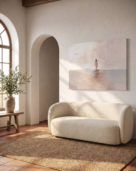 Soft cream canvas of Jesus walking into the light, hung above a bouclé sofa in a sunlit Mediterranean living room