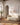 Soft cream canvas of Jesus walking into the light, hung above a bouclé sofa in a sunlit Mediterranean living room