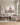 Beige wildflower Jesus and lamb canvas above a linen sectional in a panelled estate living room