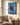 Jesus and woman shoreline canvas above a linen armchair with an open Bible and morning tea