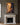 Jesus rebuking an unclean spirit canvas above a limestone fireplace mantel with brass candlesticks in a greige panelled sitting room