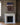 Artwork centered above a white Carrara marble fireplace mantel in a formal sitting room