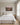 Wide canvas above an upholstered king headboard in a sunlit primary bedroom
