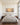 Panoramic Sea of Galilee artwork hung above an upholstered king headboard in a sunlit primary bedroom