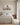 Soft neutral Jesus and lamb canvas over an oatmeal linen king headboard in a coastal villa bedroom