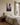 Misty forest scene of Christ offering His hand, canvas hung above a linen upholstered king headboard in a sunlit plaster bedroom