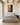 Spiritual warfare canvas above an upholstered king headboard in a Spanish colonial bedroom with timber ceiling beams