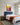 Boy version above a navy linen headboard in a boy's bedroom with white paneled walls and a toy sailboat on the nightstand