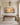 Wide sunset seascape canvas over a walnut console table in a paneled entry foyer