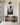 Canvas of Jesus stepping into the mud with an open hand, displayed above a walnut console in a bright entry hall with limestone floor