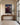 In an entry hall over a long walnut console beside a steel-framed glass door, limestone floor and a jute runner