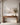 Muted coastal canvas above a walnut console with alabaster bowl and dried branches