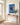 Christian canvas print above a slim oak console with eucalyptus in a bright entryway