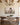 Wildflower meadow canvas on an ivory plaster wall beside a walnut dining table under oak beams