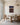 The canvas on the panelled end wall of a dining room above an oak table and cane-back chairs