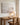 Neutral shoreline canvas behind an oak writing desk in a calm home office