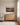 Jesus holding the sleeping child, hung over the dresser in a nursery beside a white spindle crib