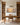 Golden sunset water scene hanging between oak bookcases above a writing desk in a home study