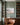 Be Still and Know meadow canvas between sage green built-in bookcases above a walnut credenza in a study