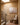 Jesus wall art on a warm plaster stair landing with a wooden chair and stacked books