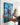 Hands holding the gallery-wrapped canvas against the wall before hanging it