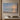 Be Still and Know painting-style canvas of an ocean sunrise with low waves on an empty beach, hanging on a taupe plaster wall