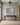 Psalm 46:10 painting-style canvas of a quiet beach at dawn above a walnut console table in a sage green entry hall