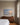 Painting-style canvas of an ocean sunrise with Be Still and know that I am God above a walnut dresser in a guest bedroom