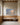 Large 48x32 Psalm 46:10 painting-style canvas of a seashore at sunrise above an oak bench in a church prayer room with arched windows