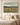 Be Still And Know canvas print above a bed in a serene neutral bedroom with warm morning light
