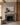 1 Peter 5:7 rowboat painting-style canvas centered above an oak mantel and stone fireplace