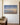 Footprints in the Sand painting-style canvas with a beach sunrise and the full poem, hanging on an ivory plaster wall above a walnut console