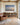 Footprints poem painting-style canvas hanging over a low oak bookcase beside a leather armchair