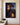 Canvas print of Jesus in profile wearing the crown of thorns with a tear on his cheek, Calvary and the empty tomb hidden in the portrait, front view on a cream plaster wall