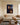 Crown of thorns Jesus canvas wall art hanging above an oatmeal boucle sofa in a bright living room with an indigo rug