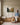 Mother on a window bench and her young daughter with a picture book on the floor, both looking up at the fruit of the Spirit canvas in a panelled playroom
