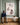 Father in a navy pullover sitting on a hall bench looks up at a canvas of Jesus rescuing the lost lamb