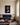Lion and sleeping lamb canvas wall art hanging above a navy wool sofa in a bright living room