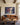 Jesus holding a man in the storm canvas hanging above a cognac leather sofa in a living room with dark oak ceiling beams