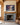 Storm rescue canvas of Jesus and a sinking man centered above an oak mantel and grey limestone fireplace