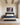 Canvas of Jesus calming the wave while holding a man, above a charcoal upholstered headboard in a bright primary bedroom