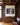 Jesus rescuing a man from the waves canvas between walnut bookcases in a study with an oxblood leather chair