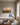 Oil-painting-style canvas of a misty pasture at dawn above an ivory linen sofa in a newly built living room
